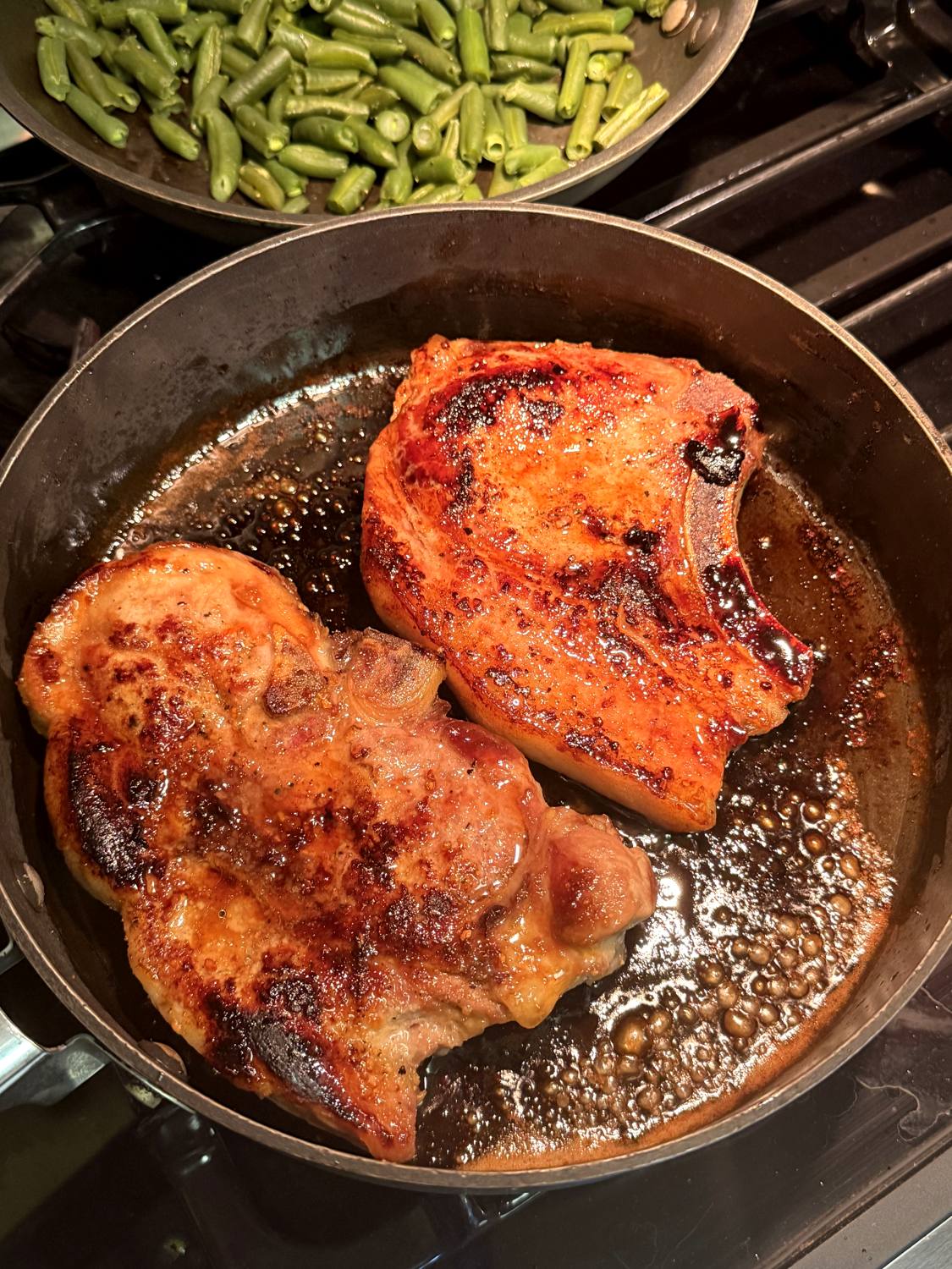 Seared bone-in pork chops from Woodcock Livestock served with green beans