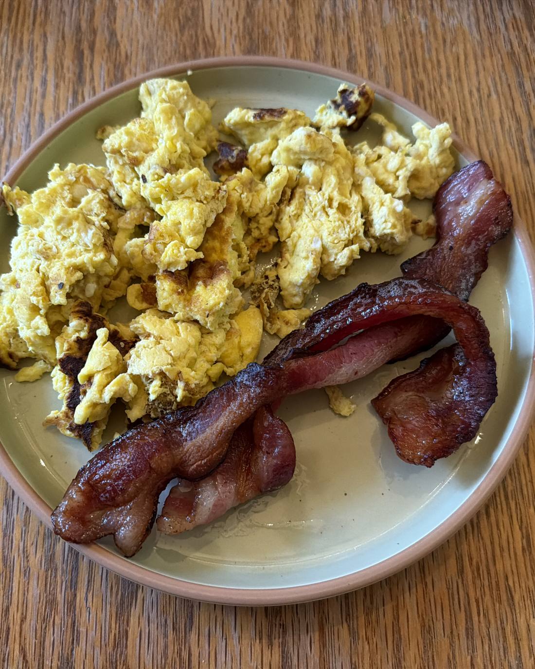Thick-cut Woodcock Livestock bacon with scrambled eggs on a plate
